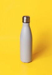 Grey insulated bottle on yellow background