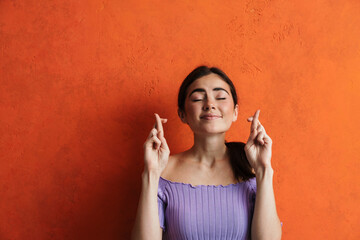 Worried young woman begging for something putting hands together