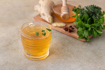 Green or herbal tea with fresh mint and thyme, cinnamon sticks, anise and ginger, light concrete...