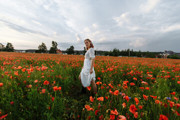 Fototapeta na wymiar portrait of a girl in a white dress and black shoes in a field of flowers