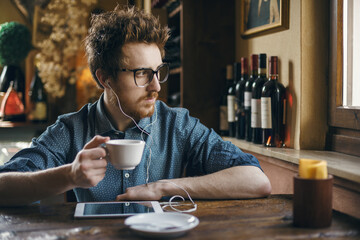 Nerd guy with tablet at the bar