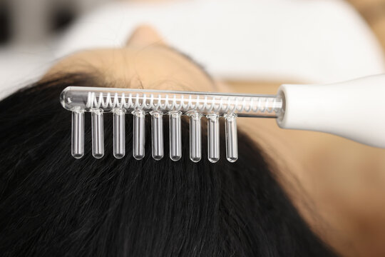 Brunette doing procedures with darsonval comb closeup