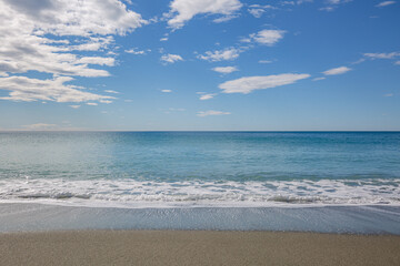 Blue sea water waves with white foam and bubbles washes the beach. Winter see. Riva Trigoso on ligurian coast