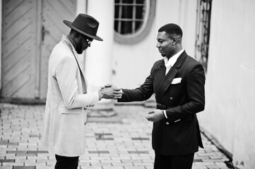 Two fashion black men shake hands each other. Fashionable portrait of african american male models....