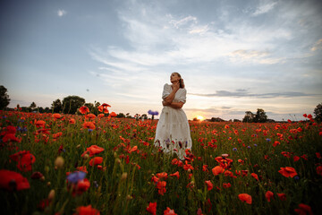 girl in a white dress in a field of red poppies
