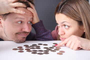 Man and woman look at coins in frustration