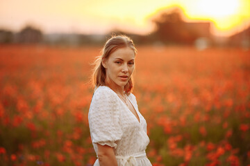 Fototapeta na wymiar portrait of a girl in a field of red poppies