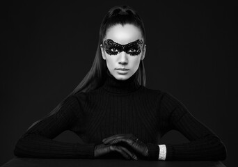 Elegant brunette woman in turtleneck sweater and sequins mask