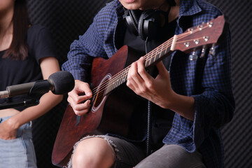 close up on young man playing acustice guitar