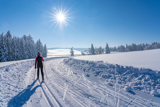 beautiful active senior woman cross-country skiing in fresh fallen powder snow in the Allgau alps near Immenstadt, Bavaria, 