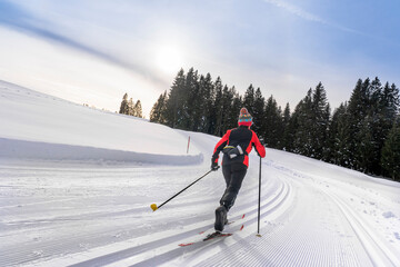 beautiful active senior woman cross-country skiing in fresh fallen powder snow in the Allgau alps near Immenstadt, Bavaria, 