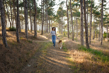 Obraz premium young woman and elderly dog walk in the countryside