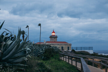 Lonely lighthouse at end of boardwalk in evening. High quality photo