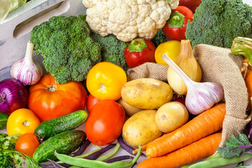 Fresh vegetables at your table. An assortment of organic vegetables: cucumbers, tomatoes, broccoli, cabbage, peppers, kohlrabi, onions, garlic, zucchini, potatoes, carrots and pumpkin.