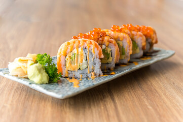 California salmon sushi rolls stuffed with salmon, avocado, topping salmon roe and spicy cream sauce. Japanese food style