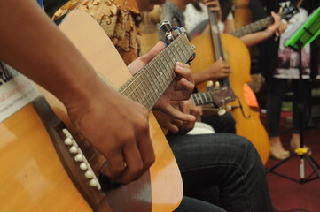 Close-up of a man playing guitar in Pasuruan