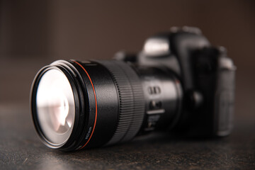 Close up in focus lens on the body of a professional digital camera.