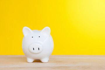 White cute piggy bank, saving money on yellow background.