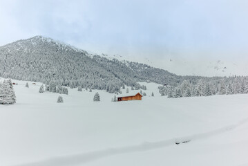 Isolated summer chalet and villages high up on the Swiss Alps covered in fresh powder snow near Davos