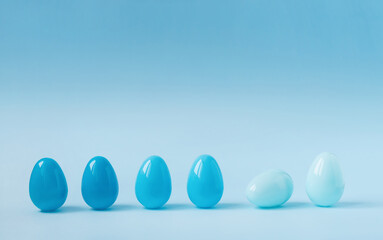 Minimalistic Easter holiday concept. Pastel blue colored chicken eggs in studio. Background with...