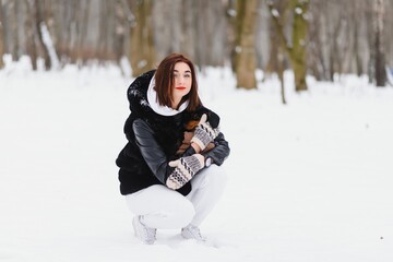 Fototapeta na wymiar Young stylish woman with a dog having fun in a winter forest.