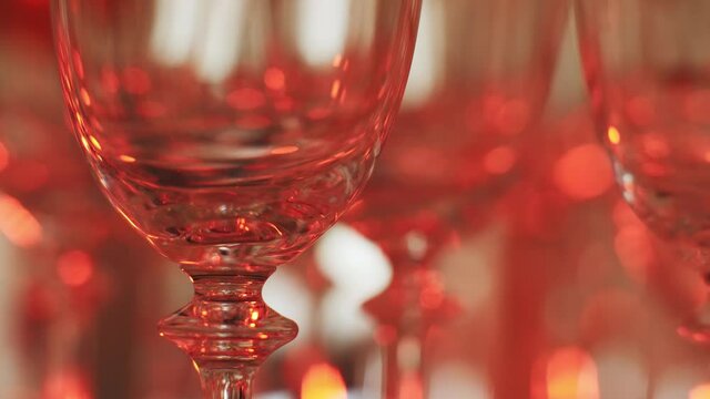 Multicolored sparkling lights reflected in transparent empty glass bocal at disco party event