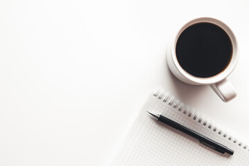 Office desk table with supplies, coffee cup and flower. Top view