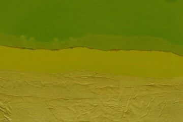 Green torn paper collage close-up. Texture made from various paper and cardboard parts. Damaged old paper background. Vintage blank wallpaper. Material design backdrop.