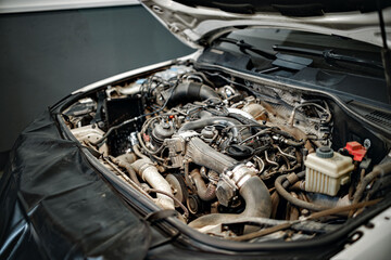 Dirty engine under the hood of a car