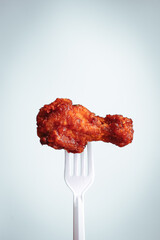 fried chicken on plastic fork with grey background, fast food Concept with copy space. 