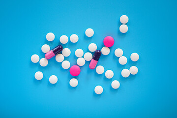 Flat lay of pills and tablets on blue background 