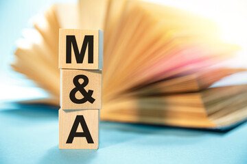 M and A - Merger and Acquisition - inscription on wooden cubes