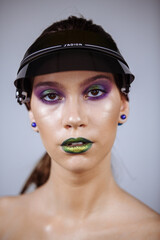 portrait of a girl with bright makeup and green lips in a summer cap