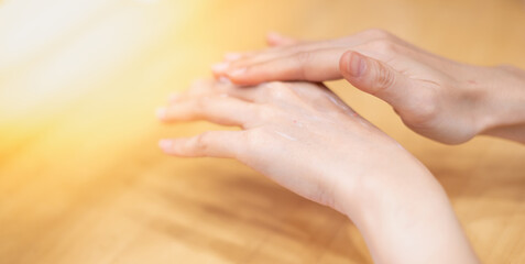 Naklejka premium Close-Up of female Hands is Applying Moisturizing Lotion Cream for Healthy Skin.