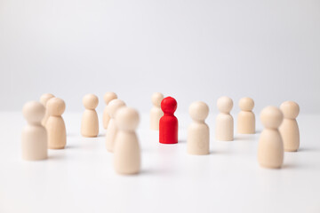 A wooden figure standing with a team to influence and empowerment. Concept of leadership, successful competition winner and Leader with influence and Social distancing for a new normal lifestyle