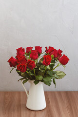 bouquet of red roses in vase, greeting card template with empty space for text
