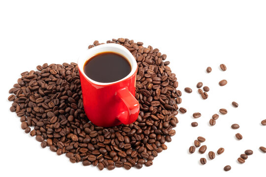 Black coffee in a red cup on the heart shape of beans isolated on white background.