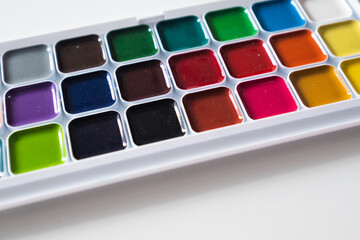 Top view of set of watercolor paints  in a box, isolated on white.