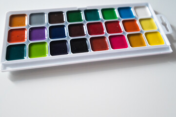 Top view of set of watercolor paints  in a box, isolated on white.