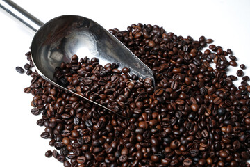 Scoop out ripe coffee beans using a large spoon made of wood and iron. Coffee beans scattered on the floor. Details texture of dark brown coffee beans. Graphic resourches for design template.
