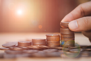 Hand putting money coin stacking for business profit growth and increase dividends rate from...