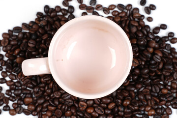 The scattered coffee beans came out of the white cup and formed a coffee writing. Blend of coffee bean with cup on wooden background. Popular wallpaper on 2021. Template design for coffee shop.