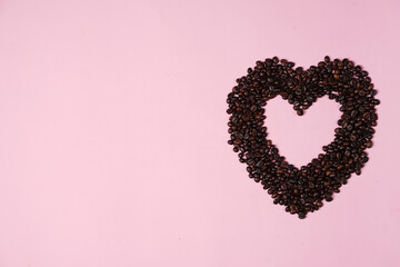 Heart shaped paper strips on a coffee bean background. The combination of coffee beans and the symbol of love to commemorate the world day of love or so-called Valentine's Day. Coffee Bean valentine.