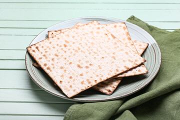 Plate with Jewish flatbread matza for Passover on wooden background