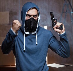 Aggressive manwith gun wearing face mask