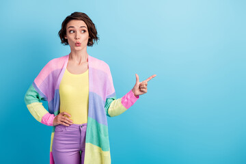 Photo portrait of shocked girl pointing finger looking at blank space isolated on pastel blue colored background