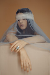 Photo portrait of brunette woman hiding face wearing silver ring make-up isolated on orange color background