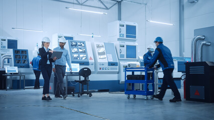 Female Chief Engineer and Male Project Manager Walk Through Modern Factory, Talking and Planning...