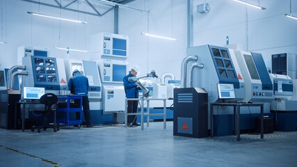 Fototapeta premium Modern Factory with Professional Workers, Engineers, Managers Working on Production Line, Workshop Management, Optimization. Industrial Facility: Equipped with CNC Machinery and robot arm Technology