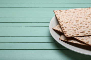 Plate with Jewish flatbread matza for Passover on wooden background